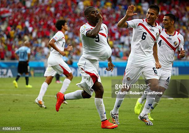 Joel Campbell of Costa Rica celebrates scoring his team's first goal with the ball under his jersey as teammates Oscar Duarte and Michael Umana run...