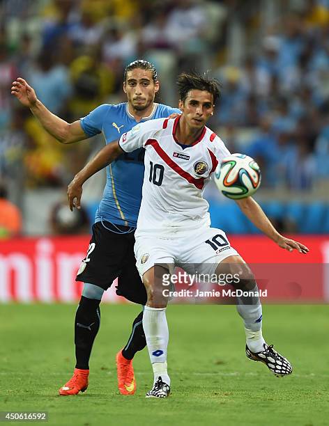 Bryan Ruiz of Costa Rica fights off Martin Caceres of Uruguay during the 2014 FIFA World Cup Brazil Group D match between Uruguay and Costa Rica at...
