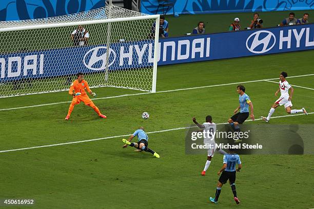 Joel Campbell of Costa Rica shoots and scores his team's first goal past Fernando Muslera of Uruguay during the 2014 FIFA World Cup Brazil Group D...