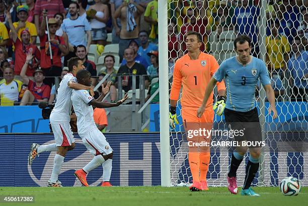 Uruguay's defender Diego Godin and Uruguay's goalkeeper Fernando Muslera look on as Costa Rica's forward Joel Campbell celebrates after scoring...