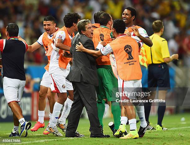 Costa Rica players celebrate with head coach Jorge Luis Pinto after their teams third goal during the 2014 FIFA World Cup Brazil Group D match...