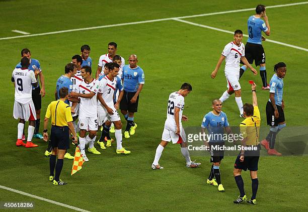 Maximilliano Pereira of Uruguay is shown a red card by referee Felix Brych after a foul on Joel Campbell of Costa Rica during the 2014 FIFA World Cup...