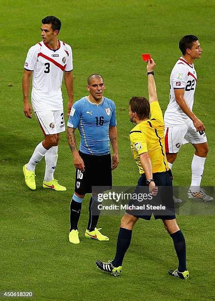 Maximilliano Pereira of Uruguay is shown a red card by referee Felix Brych after a foul during the 2014 FIFA World Cup Brazil Group D match between...