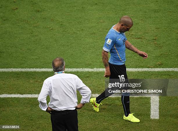 Uruguay's defender Maximiliano Pereira walks past Uruguay's coach Oscar Tabarez after being given a red card following a foul tackle against Costa...