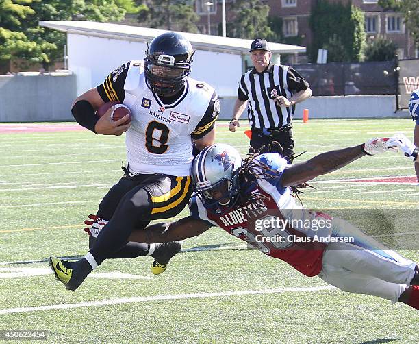 Jeremiah Masoli of the Hamilton Tiger-Cats eludes a tackle by Dominique Ellis of the Montreal Alouettes in a pre-season CFL football game at Ivor...