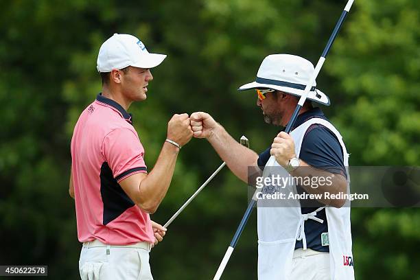 Martin Kaymer of Germany celebrates an eagle on the fifth green with his caddie Craig Connelly during the third round of the 114th U.S. Open at...