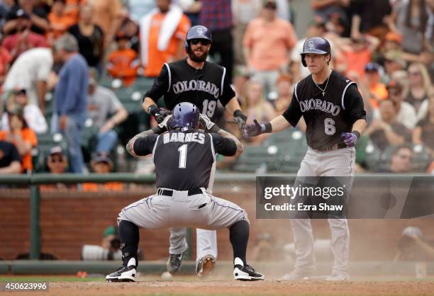 Brandon Barnes of the Colorado Rockies celebrates with Charlie Blackmon and Corey Dickerson after he hit an inside-the-park home run in the ninth...