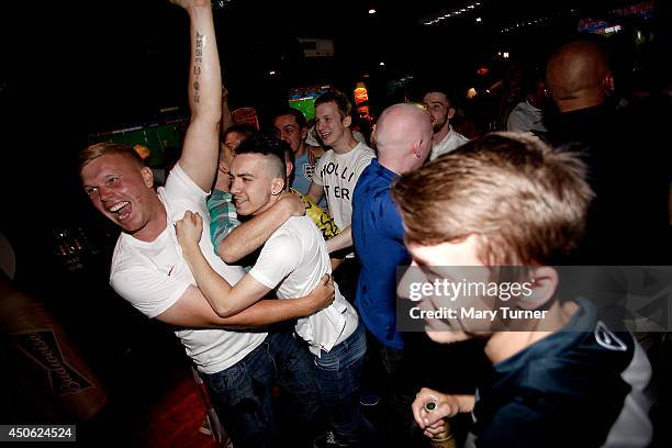 England football fans go wild in Riley's Sports Bar as their team equalise against Italy in their opening match of the 2014 FIFA World Cup on June...