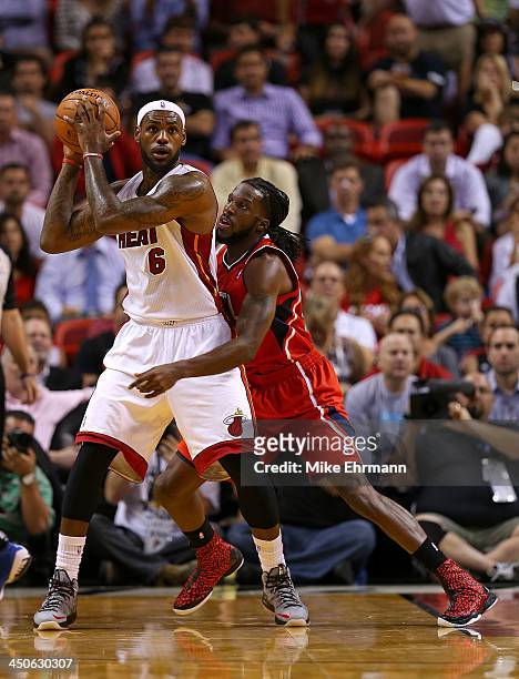LeBron James of the Miami Heat posts up DeMarre Carroll of the Atlanta Hawks during a game at American Airlines Arena on November 19, 2013 in Miami,...