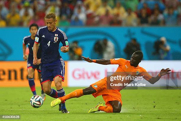 Cheick Tiote of the Ivory Coast tackles Keisuke Honda of Japan during the 2014 FIFA World Cup Brazil Group C match between the Ivory Coast and Japan...