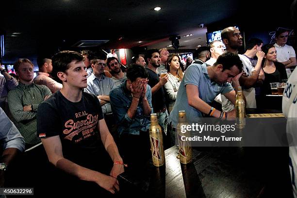 England football fans react as they watch their team lose 2-1 to Italy in their opening game of the 2014 FIFA World Cup on June 14, 2014 in London,...