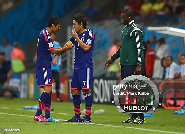 Makoto Hasebe of Japan passes the captain's armband to teammate Yasuhito Endo as he is subbed out during the 2014 FIFA World Cup Brazil Group C match...