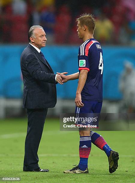 Head coach Alberto Zaccheroni of Japan shakes hands with Keisuke Honda after being defeated by the Ivory Coast 2-1 during the 2014 FIFA World Cup...
