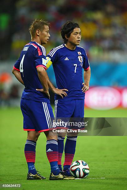Keisuke Honda and Yasuhito Endo of Japan wait to take a free kick during the 2014 FIFA World Cup Brazil Group C match between the Ivory Coast and...