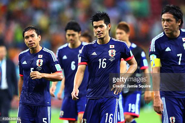 Yuto Nagatomo and Hotaru Yamaguchi of Japan walk off the field with teammates after being defeated by the Ivory Coast 2-1 during the 2014 FIFA World...