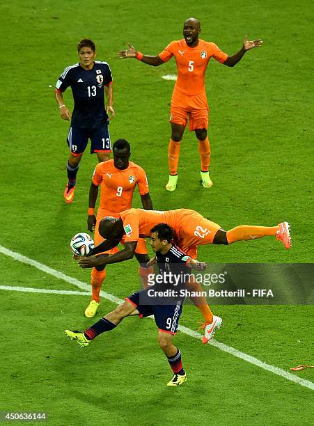 Sol Bamba of the Ivory Coast and Shinji Okazaki of Japan compete for the ball during the 2014 FIFA World Cup Brazil Group C match between Cote...