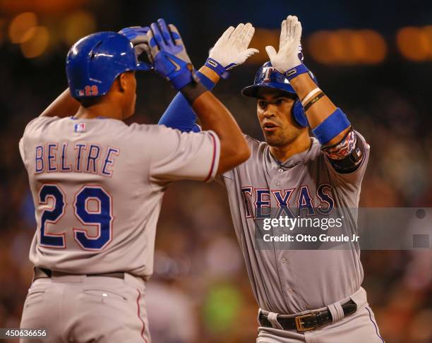 Robinson Chirinos of the Texas Rangers is congratulated by Adrian Beltre after hitting a two-run home run in the sixth inning against the Seattle...