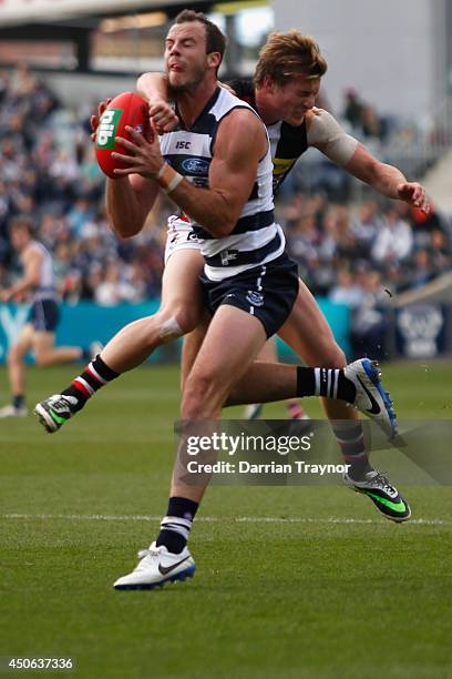 Josh Walker of the Cats marks in front of Jack Newnes of the Saints during the round 13 AFL match between the Geelong Cats and the St Kilda Saints at...