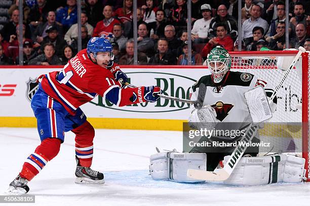 Brendan Gallagher of the Montreal Canadiens deflects the puck in front of goalie Josh Harding of the Minnesota Wild during the NHL game at the Bell...