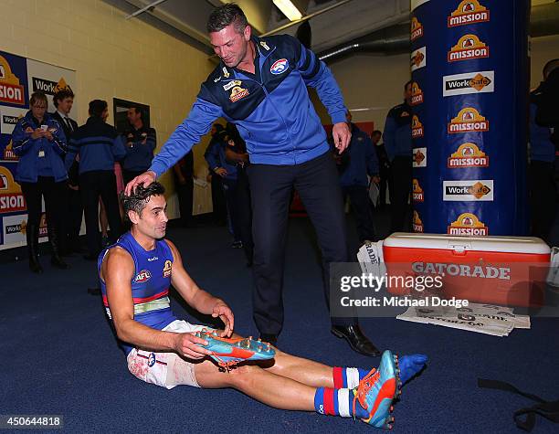 Daniel Giansiracusa of the Bulldogs gets a pat on the head by assistant coach Rohan Smith after their win during the round 13 AFL match between the...