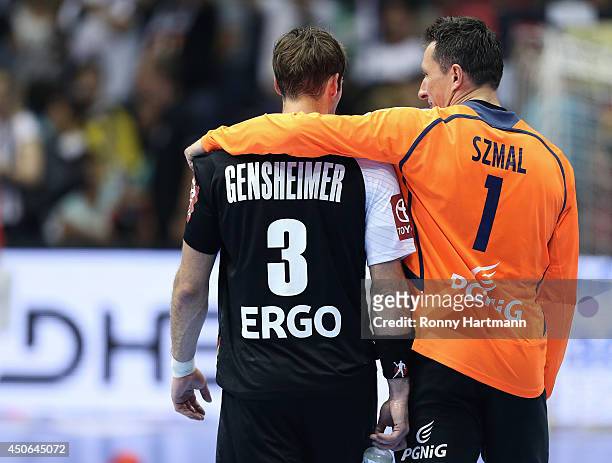 Uwe Gensheimer of Germany is comforted by goalkeeper Slawomir Szmal of Poland after the IHF World Championship 2015 Playoff Leg Two between Germany...