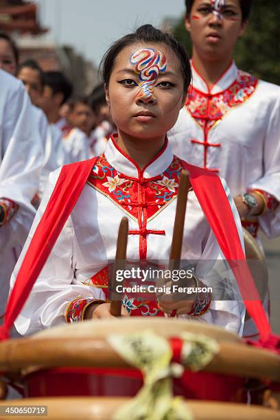 Female student from the Taipei School of Performing Arts plays a drum during a festial to honor the birthday of the Bao Sheng Emperor..