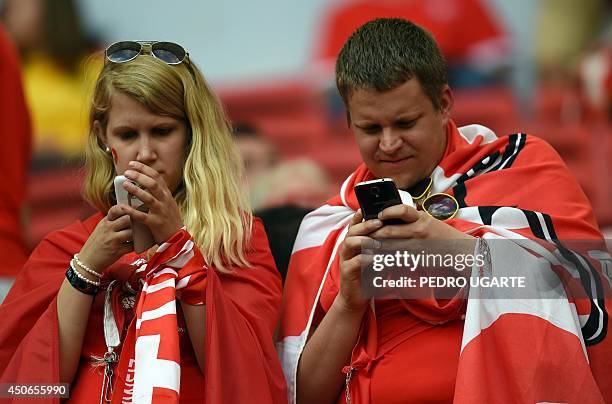 Swiss fans check the smartphones prior to a Group E football match between Switzerland and Ecuador at the Mane Garrincha National Stadium in Brasilia...