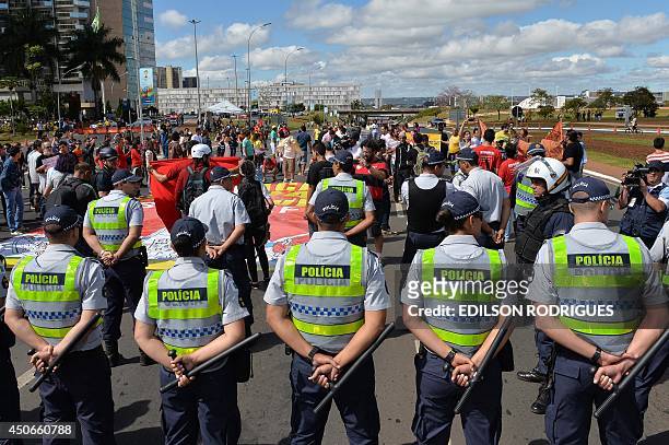 Police officers stand guard as members of social movements demonstrate against the FIFA World Cup, in Brasilia, on June 15, 2014. Brazilian President...