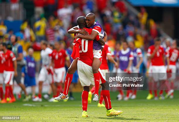 Johan Djourou of Switzerland is hugged by teammate Gelson Fernandes after defeating Ecuador 2-1 during the 2014 FIFA World Cup Brazil Group E match...