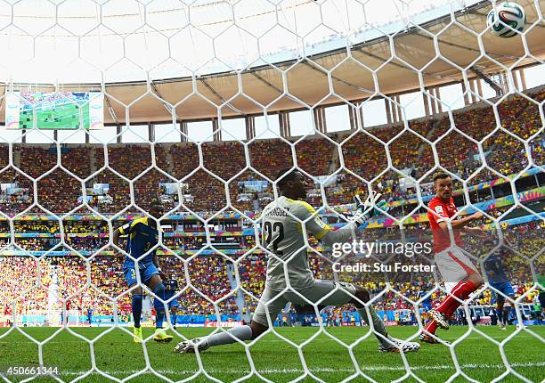 Haris Seferovic of Switzerland scores his team's second goal past goalkeeper Alexander Dominguez of Ecuador during the 2014 FIFA World Cup Brazil...