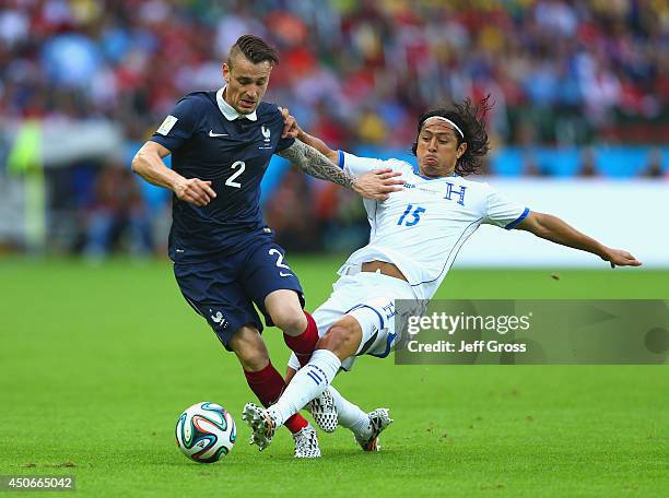 Mathieu Debuchy of France holds off a challenge by Roger Espinoza of Honduras during the 2014 FIFA World Cup Brazil Group E match between France and...
