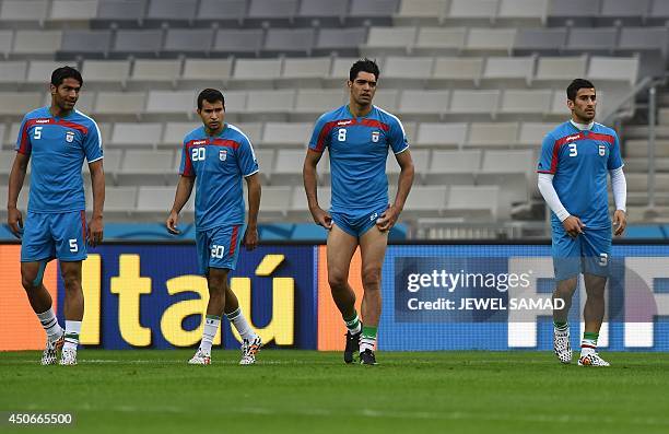 Iran's defender Amir Hossein Sadeqi, forward Karim Ansarifard, midfielder Reza Haghighi and Ehsan Hajsafi warm up during a team training session at...