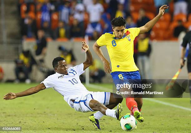 Marvin Chavez of Honduras trips up Christian Noboa of Ecuador during an international friendly match at BBVA Compass Stadium on November 19, 2013 in...