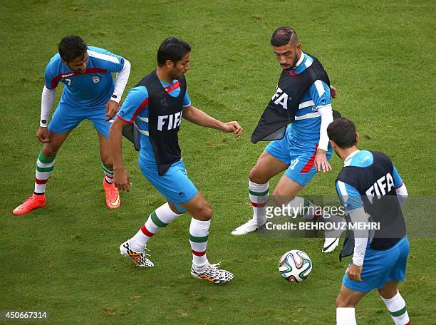 Iran's forward Masoud Shojaei, defender Amir Hossein Sadeghi and forward Ashkan Dejagah take part in a training session at Baixada Arena in Curitiba...