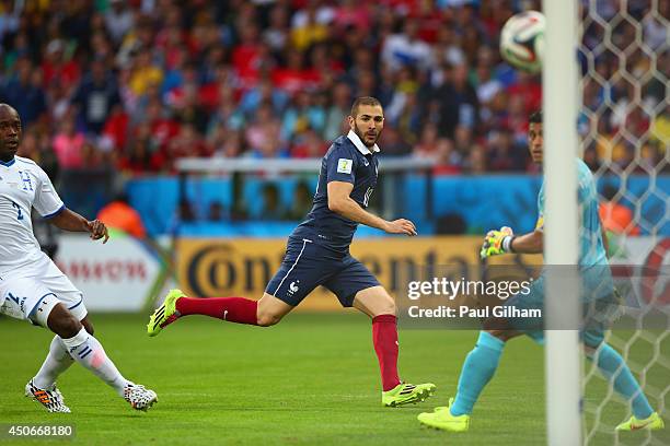 Karim Benzema of France shoots past Noel Valladares of Honduras which leads to France's second goal being scored during the 2014 FIFA World Cup...
