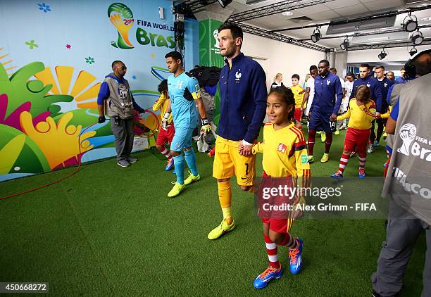 Hugo Lloris of France walks out on to the pitch with a player escort prior to the 2014 FIFA World Cup Brazil Group E match between France and...