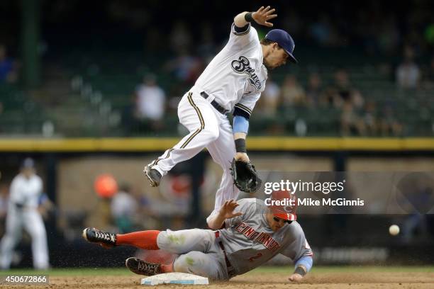 Scooter Gennett of the Milwaukee Brewers misses the grab from a wild throw from Jean Segura allowing Zack Cozart of the Cincinnati Reds second base...