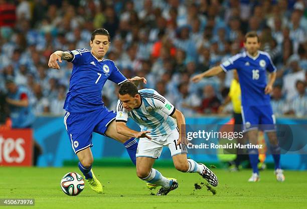 Muhamed Besic of Bosnia and Herzegovina challenges Maxi Rodriguez of Argentina during the 2014 FIFA World Cup Brazil Group F match between Argentina...