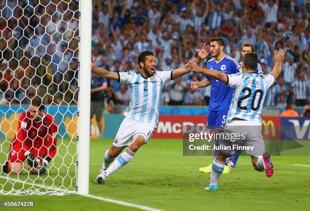 Ezequiel Garay and Sergio Aguero of Argentina celebrate their team's first goal, an own goal off Sead Kolasinac of Bosnia and Herzegovina past...