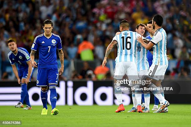 Lionel Messi of Argentina celebrates with Marcos Rojo of Argentina as Muhamed Besic of Bosnia and Herzegovina looks on dejected following Sead...