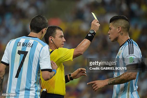 Argentina's defender Marcos Rojo is booked by Salvadoran referee Joel Aguilar during the Group F football match between Argentina and Bosnia...