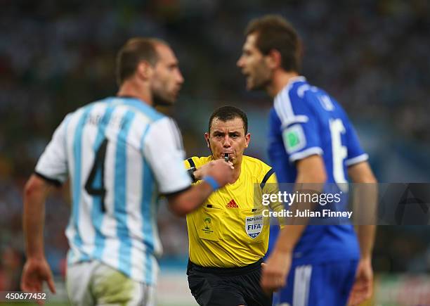 Referee Joel Aguilar reacts as Pablo Zabaleta of Argentina and Senad Lulic of Bosnia and Herzegovina clash during the 2014 FIFA World Cup Brazil...