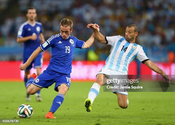 Javier Mascherano of Argentina challenges Edin Visca of Bosnia and Herzegovina during the 2014 FIFA World Cup Brazil Group F match between Argentina...