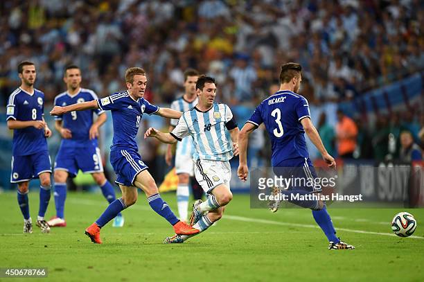 Lionel Messi of Argentina is fouled by Edin Visca of Bosnia and Herzegovina during the 2014 FIFA World Cup Brazil Group F match between Argentina and...