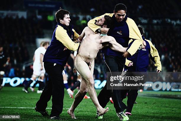 Streaker is taken from the field during the International Test Match between the New Zealand All Blacks and England at Forsyth Barr Stadium on June...