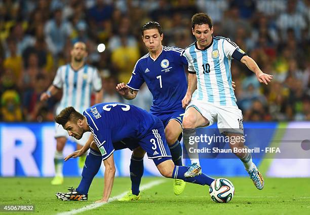 Lionel Messi of Argentina is challenged by Ermin Bicakcic of Bosnia and Herzegovina during the 2014 FIFA World Cup Brazil Group F match between...