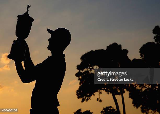 Martin Kaymer of Germany celebrates with the trophy after his eight-stroke victory during the final round of the 114th U.S. Open at Pinehurst Resort...