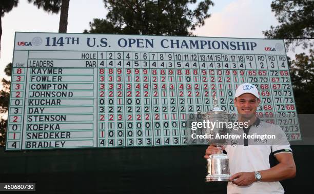 Martin Kaymer of Germany celebrates with the trophy in front of the leaderboard after his eight-stroke victory during the final round of the 114th...