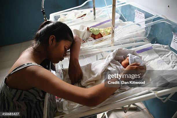 The mother of a premature baby sits by her cot in the children's and maternity ward at the Eastern Visayas Medical Centre on November 20, 2013 in...