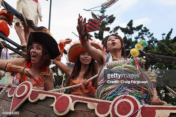 Tossing beads to the crowd from a float at the Dream Parade, Taipei..